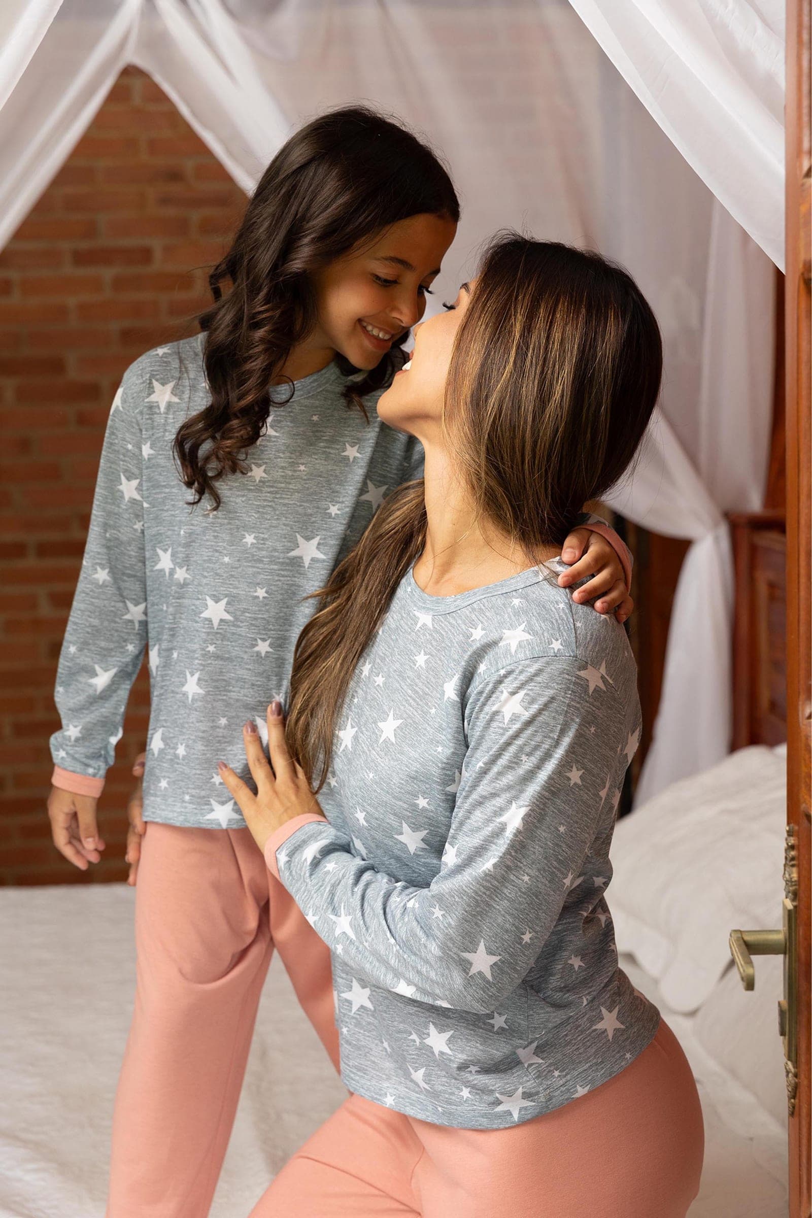 Mãe e filha com pijama cinza de estrelas e calça rosa, coleção Entrelaços